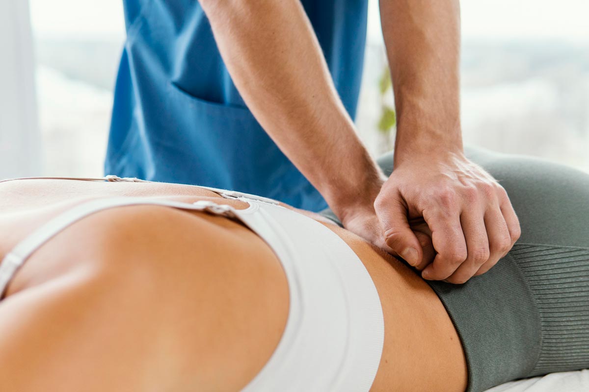 osteopathic-therapist-patient-lower-back-spine osteopath seeing patient for lower back pain